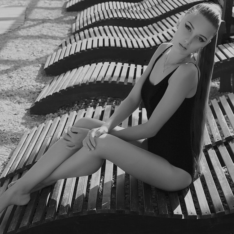 body lift patient model in a black swimsuit sunning in a lounge chair