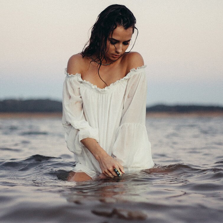 inverted nipple surgery patient model standing in a lake with a loose flowy white shirt