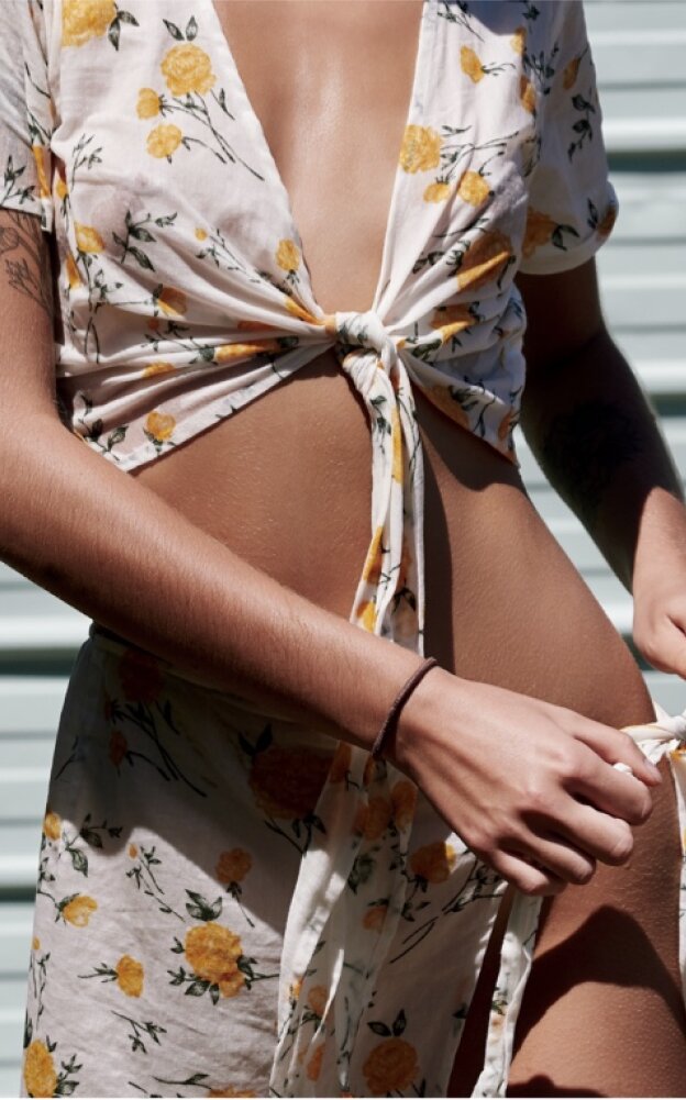 Philadelphia plastic surgery patient model with flowery sun dress and exposed abdomen